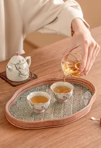 Detalle de taza y tetera de cerámica con magnolia pintada a mano, estilo elegante.