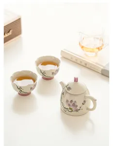Juego de tetera y tazas de cerámica con magnolia pintada a mano, elegante servicio de té.
