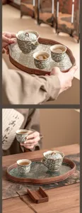 Detail view of ceramic tea set with pot and cups on wooden tray, traditional design.
