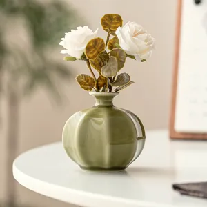 Mini ceramic vase with artificial white roses, elegant olive green decor for living room table.