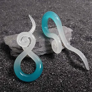 Nahaufnahme von spiralförmigen Farbverlauf-Ohrstöpseln aus Glas, einzigartiger Körperschmuck.