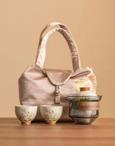 Détail du service à thé en céramique marguerite peint à la main avec théière, tasses et sac.