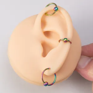 Rainbow titanium captive bead rings for body piercing, vibrant ear and nose jewelry details.