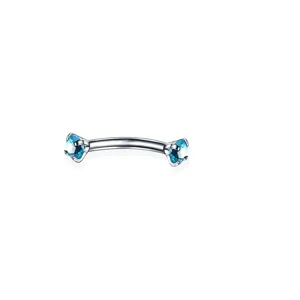 Detail close-up of stainless steel curved barbell piercing jewelry with vibrant blue crystal ends.