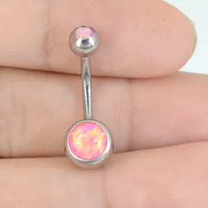Vista de detalle en primer plano del piercing de ombligo de acero con perlas de ópalo.