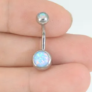 Primer plano detallado de un piercing para ombligo de acero inoxidable con ópalo sintético.