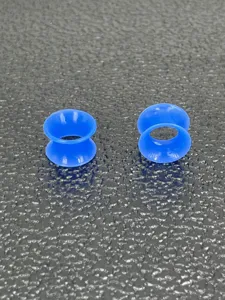 Soft silicone double flared ear tunnels detail shot, flexible body piercing stretching jewelry item.