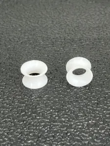Soft silicone double flare ear tunnels detail shot, white body piercing plugs for stretching.