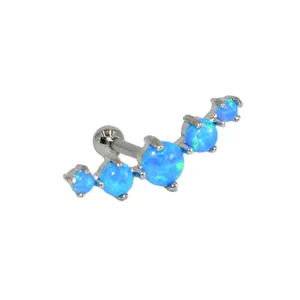 Close-up of curved blue opal cartilage piercing stud with shiny stainless steel prongs.