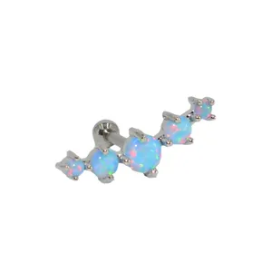 Close-up of a gradient blue opal cartilage earring, made of stainless steel for body piercing.