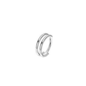 Gros plan detaille de l'anneau de piercing double avec une texture metal argent poli.