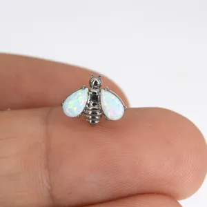Close-up view of a titanium opal bee piercing jewelry, showing intricate details and opal fire.