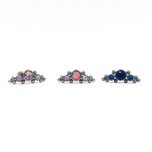 Nahaufnahme von F136 Titan Piercing Schmuck mit Opal-Clustern und kleinen Metallkugeln.