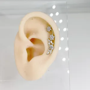 Detail shot of a 20G stainless steel rhinestone flower ear crawler cartilage piercing stud.