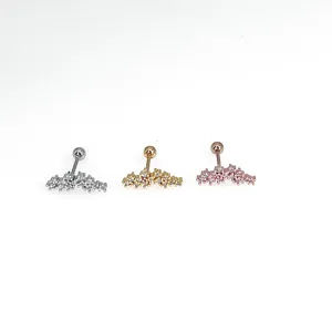 Close-up detail of three colored crystal cartilage earrings in silver, gold and rose gold.