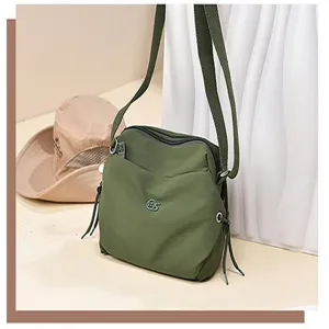 Detail view of the lightweight green nylon crossbody shoulder bag featuring multi pockets.
