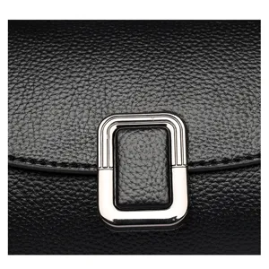 Detailaufnahme einer schwarzen PU-Leder-Umhängetasche mit polierter silberner Metallschnalle.
