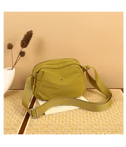 Yellow green canvas crossbody bag detail, wide strap, shell bag design, casual daily use.