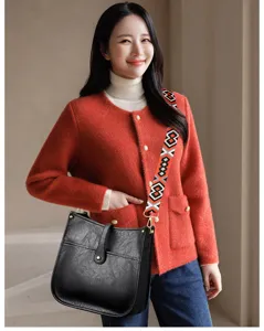 Fashionable black faux leather bucket crossbody bag with wide geometric pattern strap for women.