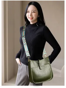 Stylish dark green bucket shoulder bag with wide patterned strap and practical front pocket.