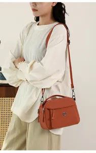 Detailed view of the multi-pocket nylon crossbody bag worn by the model, showing fabric and straps.