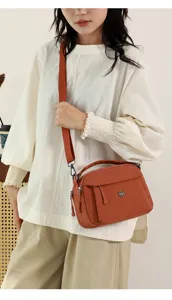 Detail view of multi-pocket casual crossbody bag showing adjustable strap and zipper.
