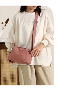 Minimalist casual shell crossbody shoulder bag in mauve pink fabric with wide adjustable strap.