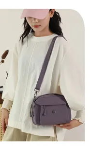 Detailed view of the multi-layer casual canvas crossbody bag in purple with wide strap.