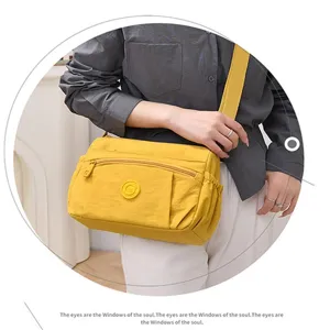 Nylon crossbody bag detail, yellow multi-pocket shoulder bag with adjustable wide strap.