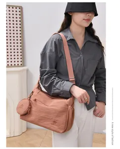 Casual nylon shoulder bag detail view with attached coin purse and adjustable strap.