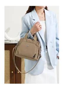 Vue détaillée d'un sac à bandoulière léger en nylon kaki, avec des poches pratiques.