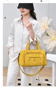 Vista di dettaglio della borsa a tracolla in nylon giallo con tasche con zip multiple.