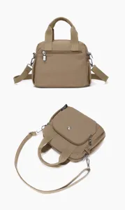 Vue détaillée du sac bandoulière en nylon kaki avec double poignée et poches frontales pratiques.