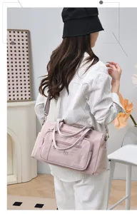 Vista dettagliata della borsa a spalla rosa in nylon, evidenziando texture e dettagli.