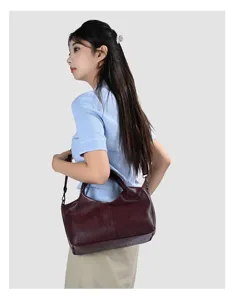 Detailed side view of a stylish women soft PU leather shoulder handbag in dark red color.
