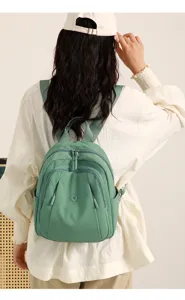 Casual nylon travel backpack detail view, featuring multi-pocket design and fresh green color.