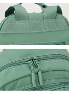 Green nylon backpack detail view, durable oxford cloth casual daily daypack zipper pull.