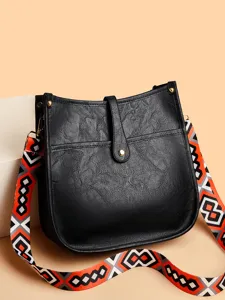 Black leather crossbody bag for women, featuring a vibrant geometric patterned wide strap.