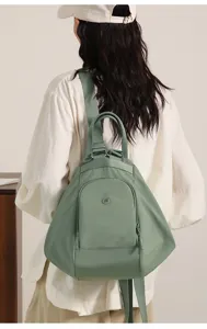 Detail view of the stylish green multi-function commuter backpack worn on model back.