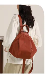 Detailed shot of a stylish brown multi-functional women backpack worn by model, casual design.