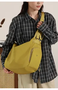 Large capacity yellow shoulder dumpling bag for women, casual commuter crossbody bag with wide strap.