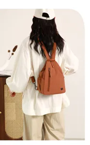 Detail view of the multi-layer nylon chest backpack in brown, showing casual outdoor style.