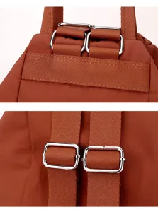 Detailed view of the durable brown backpack straps and adjustable metal buckles for use.