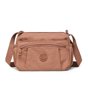 Casual nylon crossbody bag for women with multiple zippered compartments and adjustable strap.
