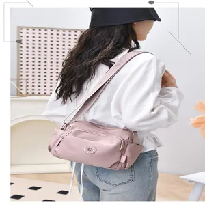 Casual pink nylon crossbody shoulder bag for women, stylish multi-pocket daily commute handbag.