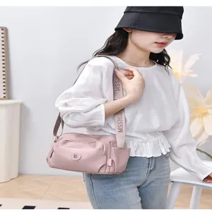 Pink nylon crossbody shoulder bag for women, casual multi-pocket daily travel handbag.