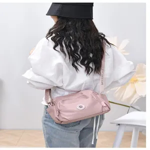 Detailed view of the pink nylon shoulder crossbody bag, featuring wide printed straps.