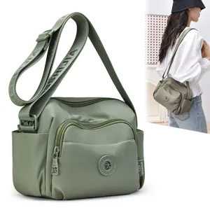 Green nylon crossbody shoulder bag with multi-pocket design, large capacity and strap logo.