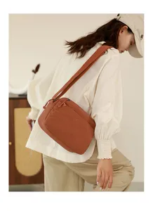 Dettaglio della borsa a tracolla in nylon casual con tessuto testurizzato e logo.