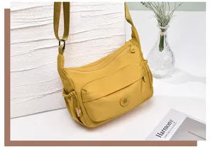 Detail view of the yellow nylon crossbody shoulder bag featuring multiple functional pockets.